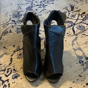 Black peep toe heels with a gold side zipper,